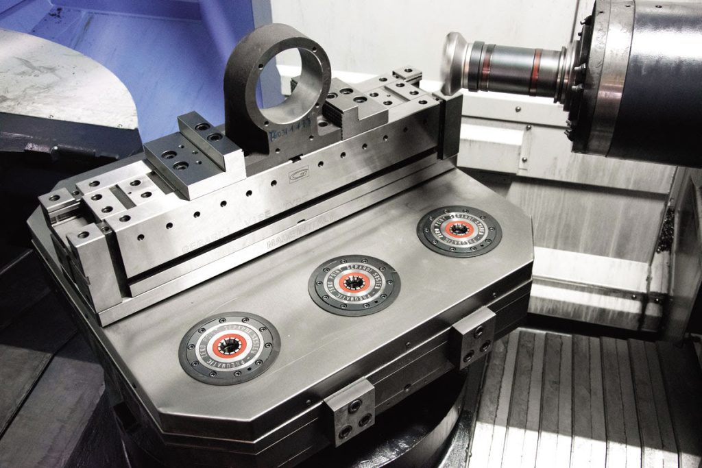 Станочные тиски, установленные на горизонтальном столе вертикального фрезерного обрабатывающего центра 